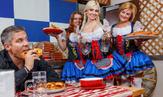 Costumed and stockinged beer girls compete for a big fat sausage